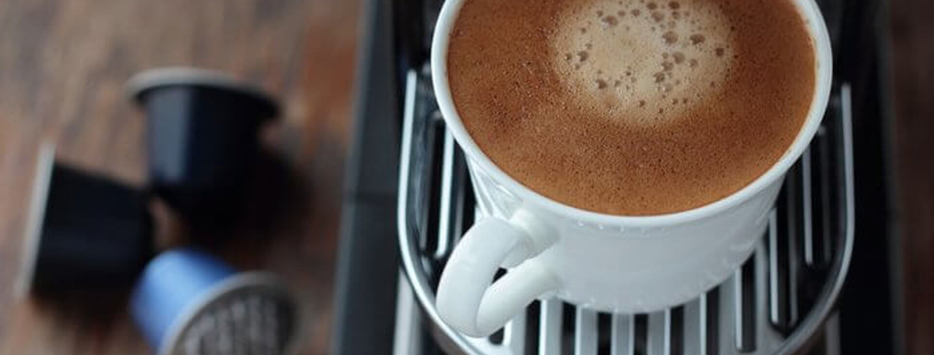 Coffee making made easy full cup of coffee with capsules in the background
